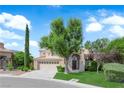 Attractive two-story home with an arched doorway, well-kept lawn, and a spacious three car garage at 2417 Chestnut Hill St, Las Vegas, NV 89134