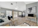 Bright living room with wood floors, ceiling fan, neutral walls, and sliding glass doors to the backyard at 2430 Sungold Dr, Las Vegas, NV 89134