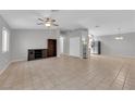Spacious living room featuring tile flooring, ceiling fan, and neutral paint, seamlessly connecting living and kitchen areas at 2432 Shady Hill Ave, Las Vegas, NV 89106
