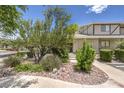 Charming front entrance with mature trees and desert landscaping, offering a tranquil approach to the home at 2761 Carnation Ln # 1, Henderson, NV 89074