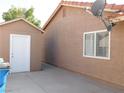 Home exterior with a shed, stucco siding, and well-maintained concrete walkway at 391 Newbury Ct, Henderson, NV 89015