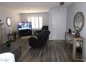 Cozy living room featuring laminate flooring, shutters and a modern television at 391 Newbury Ct, Henderson, NV 89015