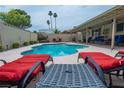 Relaxing backyard pool area with lounge chairs, outdoor seating and mature landscaping at 4161 Royalhill Ave, Las Vegas, NV 89121