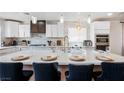 Modern kitchen with a large island, breakfast bar, sleek countertops, and stainless steel appliances at 4774 Walteta Way, Las Vegas, NV 89119