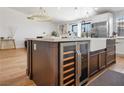 Kitchen island featuring a built-in wine fridge, stainless steel sink, and modern finishes at 4774 Walteta Way, Las Vegas, NV 89119