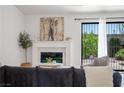 Bright living room with modern fireplace, designer accents, and view to the outdoor landscape at 4774 Walteta Way, Las Vegas, NV 89119