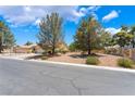 Well-maintained single-story home with mature trees and a low-maintenance desert landscape at 4909 Desert Poppy Dr, Las Vegas, NV 89130
