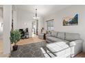 Bright living room with neutral walls, plush gray furniture, and a decorative geometric rug at 4916 White Jade St, North Las Vegas, NV 89081
