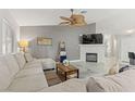 Comfortable living room with fireplace, ceiling fan, and cozy sectional sofa at 5108 Molveno Ct, Las Vegas, NV 89130