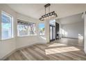 Bright living room featuring hardwood floors, multiple windows, and modern lighting fixtures at 5825 Bent Branch Ln, Las Vegas, NV 89142