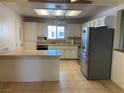Bright kitchen featuring white cabinets, stainless steel appliances, and a tiled floor at 6241 Pinewood Ave, Las Vegas, NV 89103