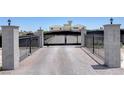 Gated driveway leading to an estate, providing privacy and security with landscaped pillars at 7590 Rancho Destino Rd, Las Vegas, NV 89123