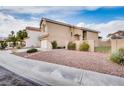 This home has a two car garage, rock landscaping, a green gate, and a stucco exterior at 7816 Calico Flower Ave, Las Vegas, NV 89128