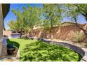Well-manicured backyard featuring artificial turf and a soothing hot tub for relaxation at 8544 Garden Valley Ct, Las Vegas, NV 89178