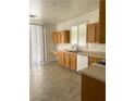 Well-lit kitchen features wood cabinets, tile floors, a modern sink, and lots of counter space at 8756 Shady Pines Dr, Las Vegas, NV 89143