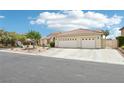 Charming single-story home featuring desert landscaping, a three-car garage, and a tile roof at 9410 Stone Castle Way, Las Vegas, NV 89123