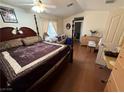 Spacious main bedroom with a four-poster bed, wood floors, and comfortable seating area at 977 Country Skies Ave, Las Vegas, NV 89123