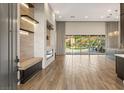 Spacious living room with a modern fireplace, wood floors, and sliding glass doors to backyard at 10179 Emerald Sunset Ct, Las Vegas, NV 89148