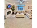 Bright living room with large sectional, electric fireplace, ceiling fan, and sliding glass doors at 10411 Rose Palisade St, Las Vegas, NV 89141