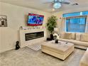 Comfortable living room with a fireplace, large TV, and neutral decor, perfect for relaxation at 10411 Rose Palisade St, Las Vegas, NV 89141