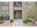 Stylish townhome entrance with stone walkway, desert landscaping, and cozy front porch at 1120 Tektite Ave, Henderson, NV 89011