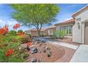 Beautiful home with desert landscaping, colorful flowers, and a paved walkway leading to the front door at 2292 Saxtons River Rd, Henderson, NV 89044