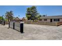 Expansive front yard with mature trees, concrete block fence and a glimpse of a neighboring house at 2315 Lincoln Rd, Las Vegas, NV 89115