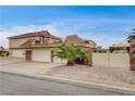 A three-car garage alongside a gated entrance with a lovely Palm tree at 301 E Longacres Dr, Henderson, NV 89015