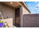 A front door with security screen next to a brick wall and a lush plant at 3782 Neblina Dr, Henderson, NV 89052