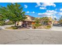 Charming single-Gathering home featuring a circular driveway, mature landscaping, and a vibrant red front door at 3930 Maranatha Cir, Las Vegas, NV 89103