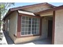 View of the front of a stucco home with brown trim and large bright window at 4041 Saguaro Ln, Las Vegas, NV 89110