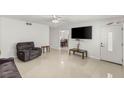 Light filled living room with tile floors, a large TV, front door, and dining area at 4201 Sunrise Ave, Las Vegas, NV 89110