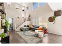 Bright, open living room featuring a staircase, hardwood floors, and large windows at 5674 Moccasin Point St, Las Vegas, NV 89148