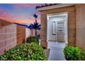 Inviting home entrance with security gate, lush bushes, and neutral exterior paint at 6187 Novelty St, Las Vegas, NV 89148