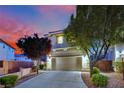 Charming home featuring a two-car garage, desert landscaping, and a picturesque sunset backdrop at 6187 Novelty St, Las Vegas, NV 89148