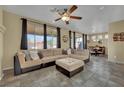 Comfortable living room with a large sectional sofa, ceiling fan, and backyard views at 6187 Novelty St, Las Vegas, NV 89148