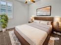 This bedroom boasts hardwood floors, a ceiling fan, and a large window with wooden blinds at 6312 Conlon St, North Las Vegas, NV 89081