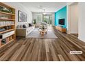 Bright, virtually staged living room with contemporary furniture, wood floors, and a vivid accent wall at 6312 Conlon St, North Las Vegas, NV 89081