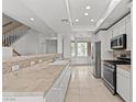 Bright, open kitchen with white cabinets, stainless steel appliances, and tile countertops at 664 Peachy Canyon Cir # 103, Las Vegas, NV 89144