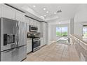 Well-lit kitchen with stainless steel appliances, tiled counter and a view out the large window at 664 Peachy Canyon Cir # 103, Las Vegas, NV 89144