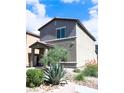 Two story home with desert landscaping and partial view of the side yard and the covered entryway at 7411 Sunray Point St, North Las Vegas, NV 89084