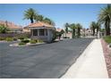 Gated community entrance with a security booth surrounded by palm trees at 7955 Canto Ave, Las Vegas, NV 89147