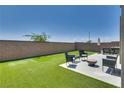Well-manicured backyard featuring artificial turf, patio, and outdoor seating, perfect for entertaining at 8254 Palladium St, Las Vegas, NV 89113