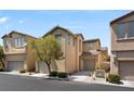 Two-story home with tan exterior and attached garage, highlighted by a mature tree and well-kept landscaping at 8448 Quarentina Ave, Las Vegas, NV 89149