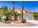 Beautiful two-story house with desert landscaping including palm trees and gravel at 9500 Catalina Cove Cir, Las Vegas, NV 89147