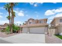 Charming two-story home with a well-manicured lawn, palm trees, and a three car garage at 9500 Catalina Cove Cir, Las Vegas, NV 89147