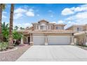 Charming two-story home with a well-manicured lawn, palm trees, and a three car garage at 9500 Catalina Cove Cir, Las Vegas, NV 89147