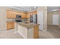 Bright kitchen with stainless steel appliances, wooden cabinetry, and a spacious island, perfect for cooking and entertaining at 9709 Fast Elk St, Las Vegas, NV 89143