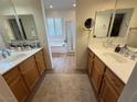 This bathroom has dual vanities, a soaking tub, and modern fixtures at 1146 Olivia Pkwy, Henderson, NV 89011