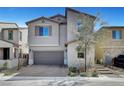 Two-story home features a gray exterior, attached two-car garage, paver driveway, and manicured landscaping at 15 Santo Mio Ct, Henderson, NV 89011